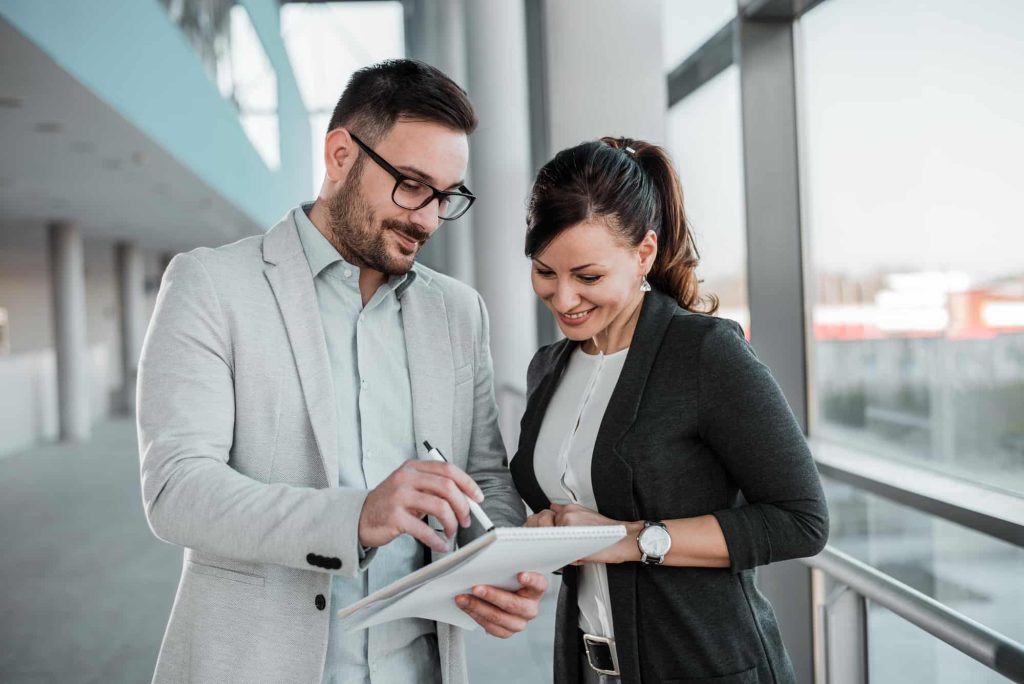 2 business professionals discussing outsourcing investment strategy