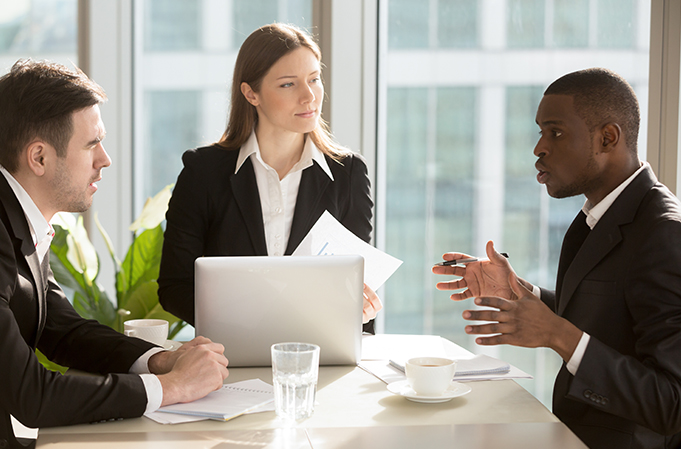 Business professionals in a serious discussion around compliance and risk management strategies