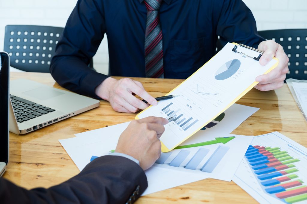 Professionals reviewing charts and graphs, highlighting Grand Cayman services.