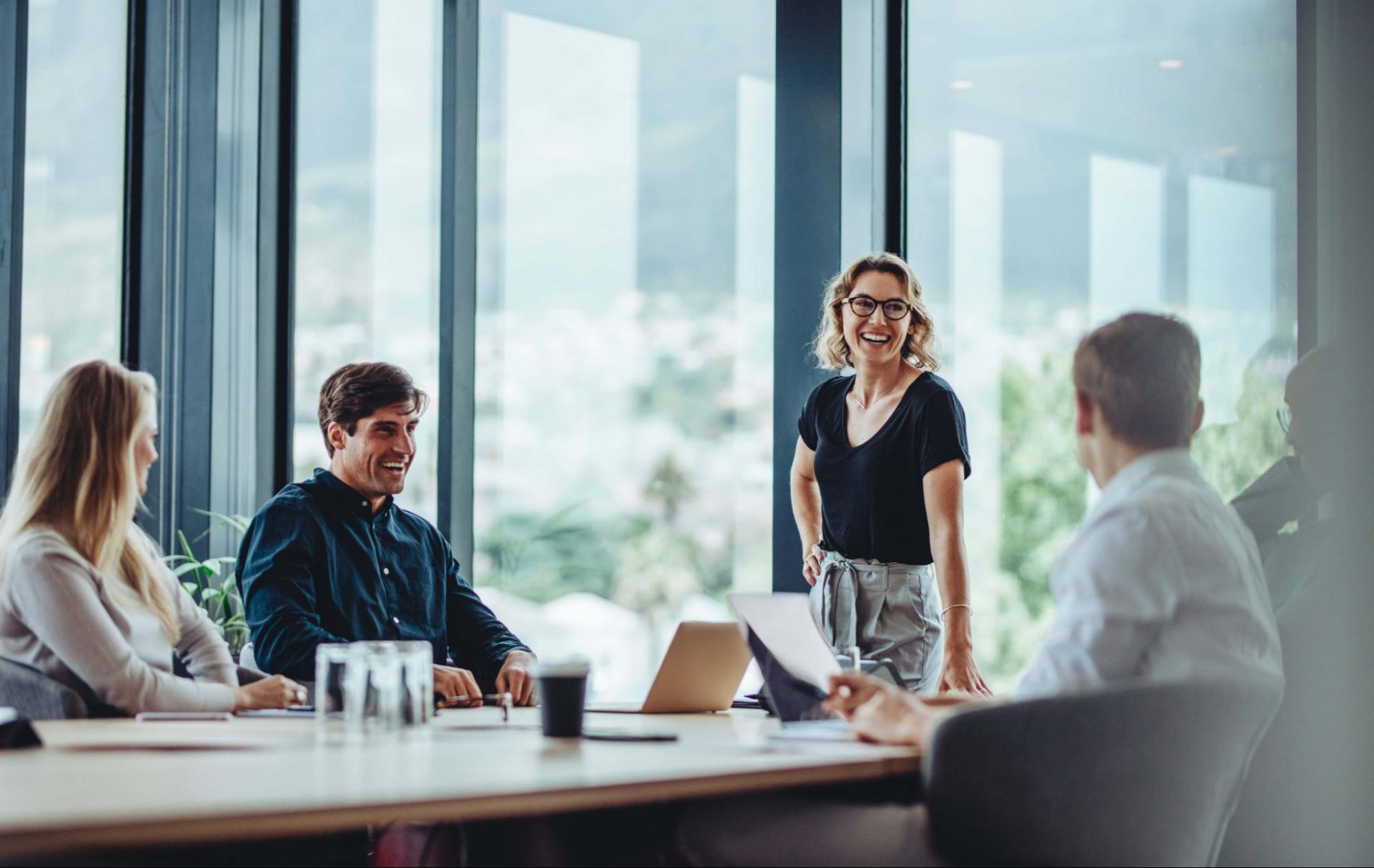 Team having a relaxed meeting in a modern office with large windows
