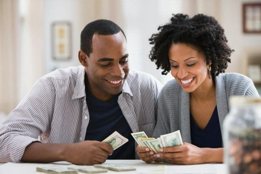 a couple counting money and smiling