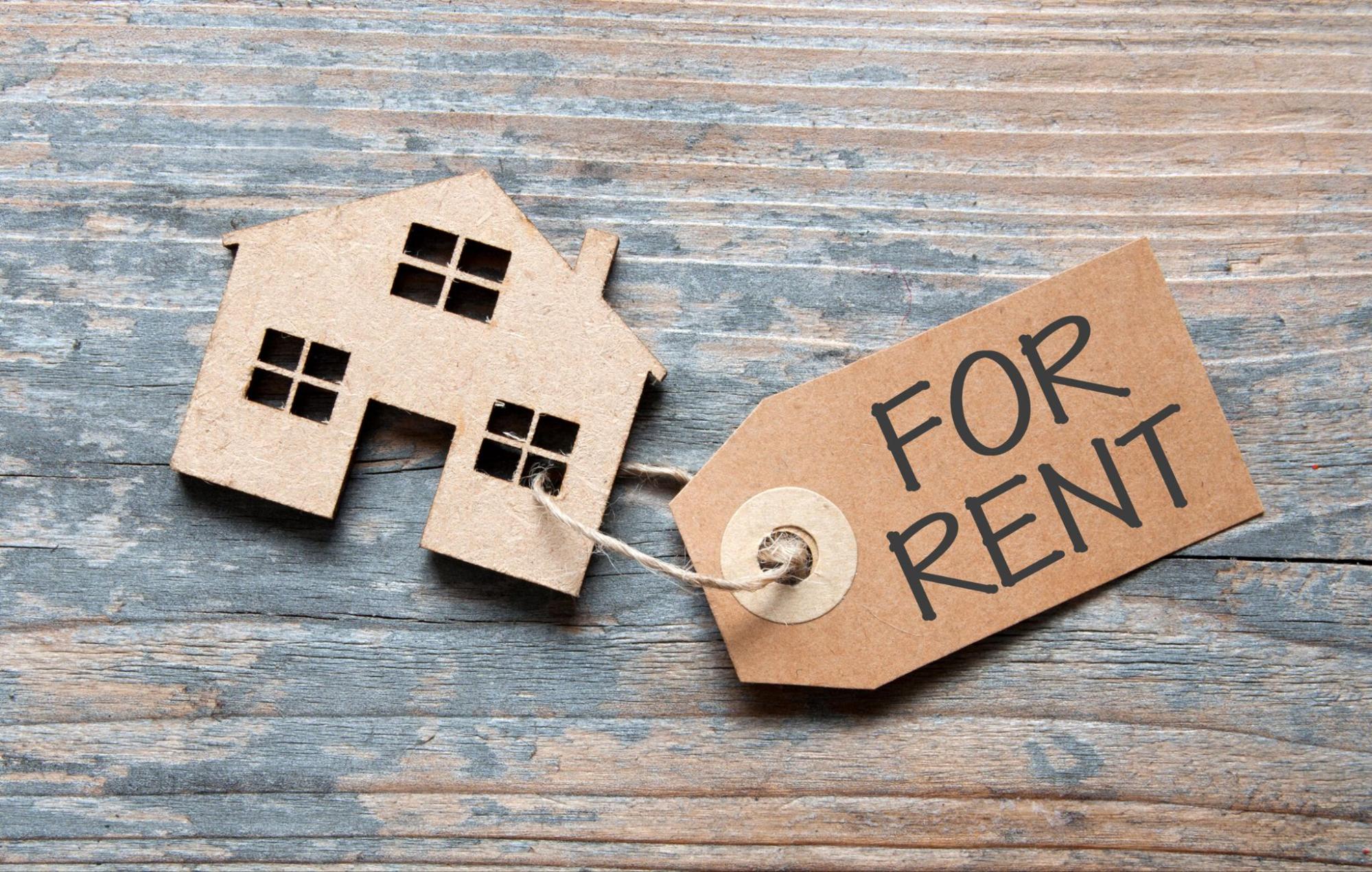 a miniature house with a for rent tag on it