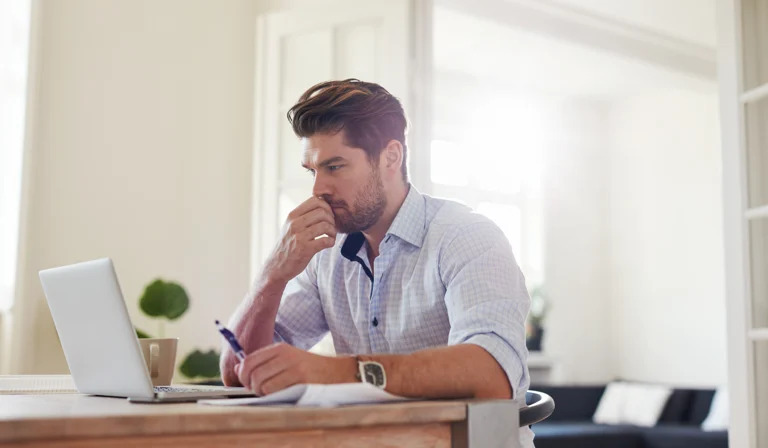 a person working on a laptop, focusing on something