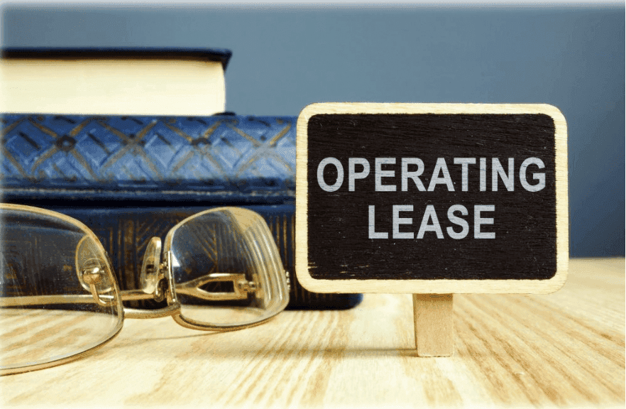 a small board with the operating lease written on it, glasses on the side