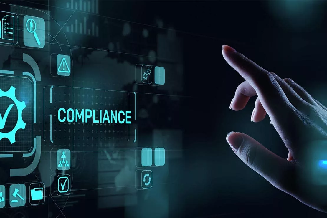 Hand reaching toward a digital screen displaying the word COMPLIANCE
