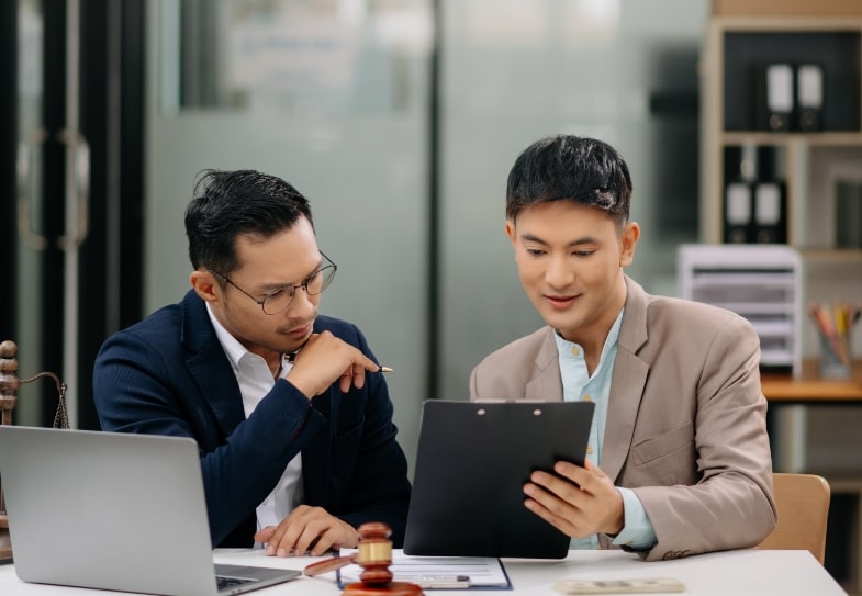 Two men discussing a contract in a legal office setting